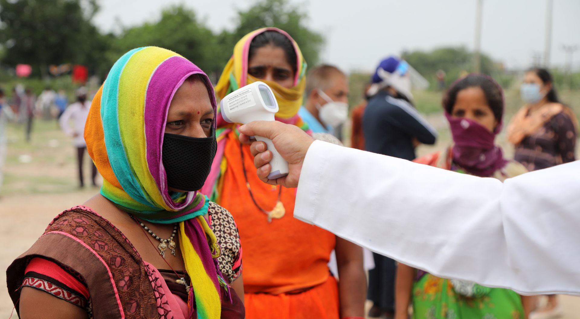 epa08478983 A health worker checks the body temperature of migrant labourers from Chhattisgarh state before sending them to their native places as they are stranded in an open ground, in Jammu, India, 11 June 2020. Hundreds of migrant labourers struck in Jammu who have left their rented houses to go back to their native places allege that the landlords are not allowing them to get back after they left the rented houses and now labourers along with families are spending nights in open ground from past five days.  EPA/JAIPAL SINGH