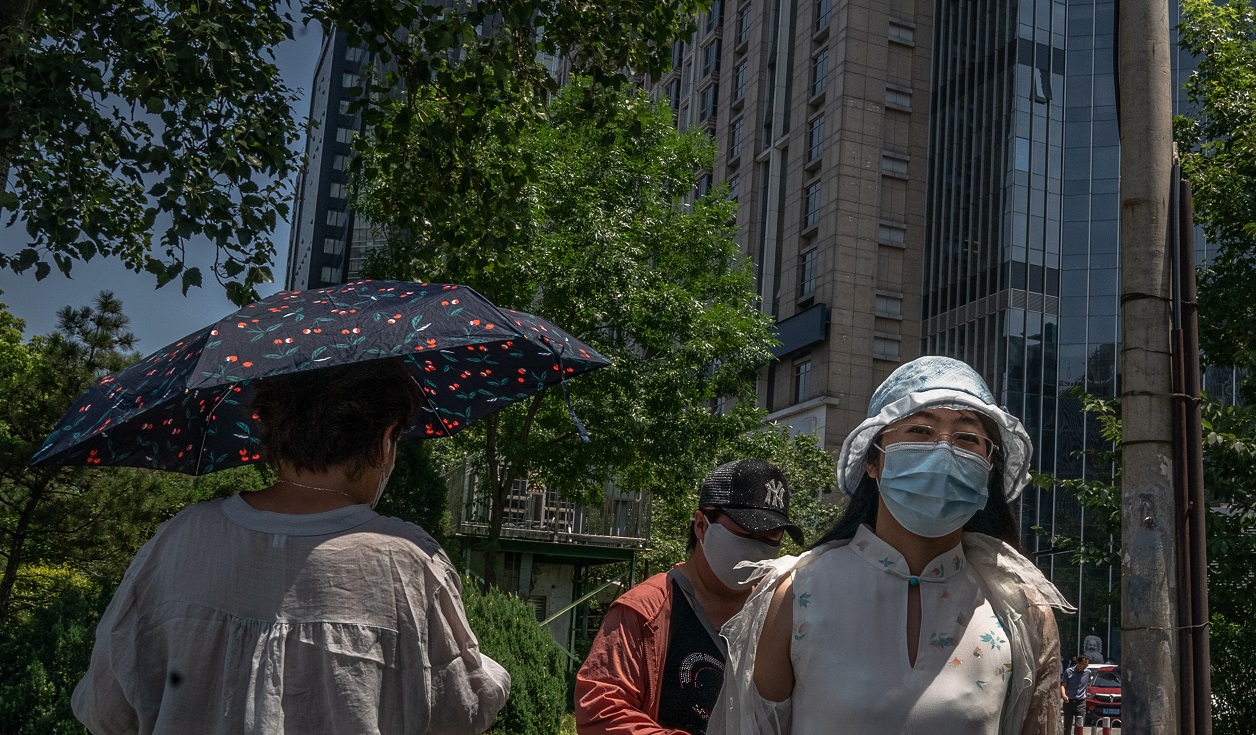 epa08480249 People wearing protective face masks walk in Beijing, China, 12 June 2020. Beijing confirmed on 11 June its first locally transmitted case of COVID-19 after over 50 days without a local transmission.  EPA/ROMAN PILIPEY