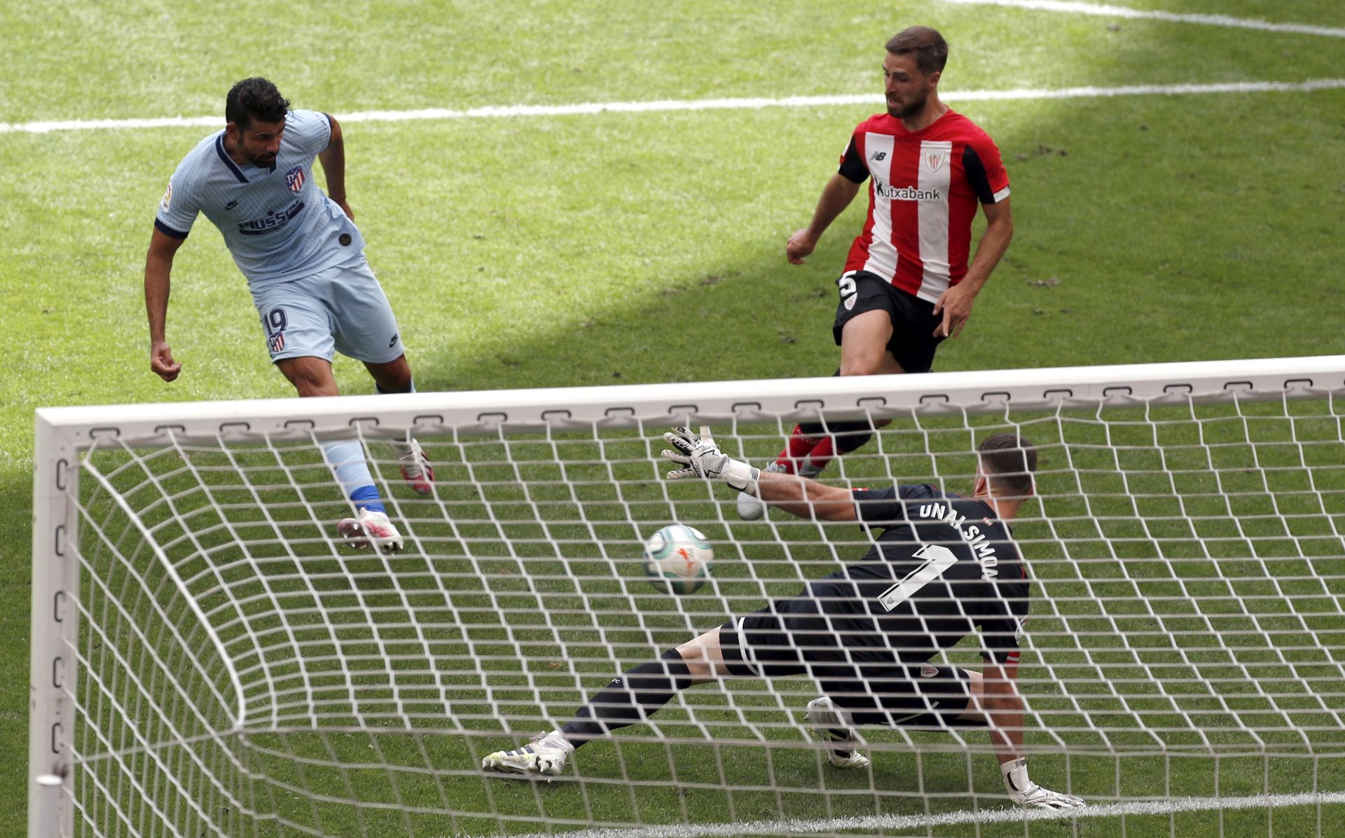 epa08484820 Atletico Madrid's forward Diego Costa (L) scores the equalizer against Athletic Bilbao's goalkeeper Unai Simon (R) during the LaLiga soccer match between Athletic Bilbao and Atletico Madrid, in Bilbao, Basque Country, northern Spain, 14 June 2020.  EPA/Luis Tejido