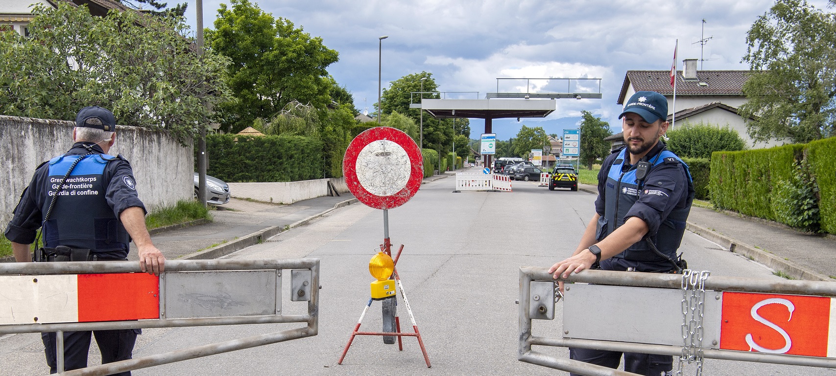 epaselect epa08485213 Two border guards opens the barrier that closed access to customs, in Thonex near Geneva, Switzerland, 14 June 2020. Concrete blocks closed the road at the Swiss-French border during the state of emergency due to the coronavirus COVID-19. Switzerland will open its borders to the EU and EFTA countries and to the United Kingdom on Monday, June 15. Border controls within the Schengen area are abolished and shopping tourism is allowed again.  EPA/MARTIAL TREZZINI
