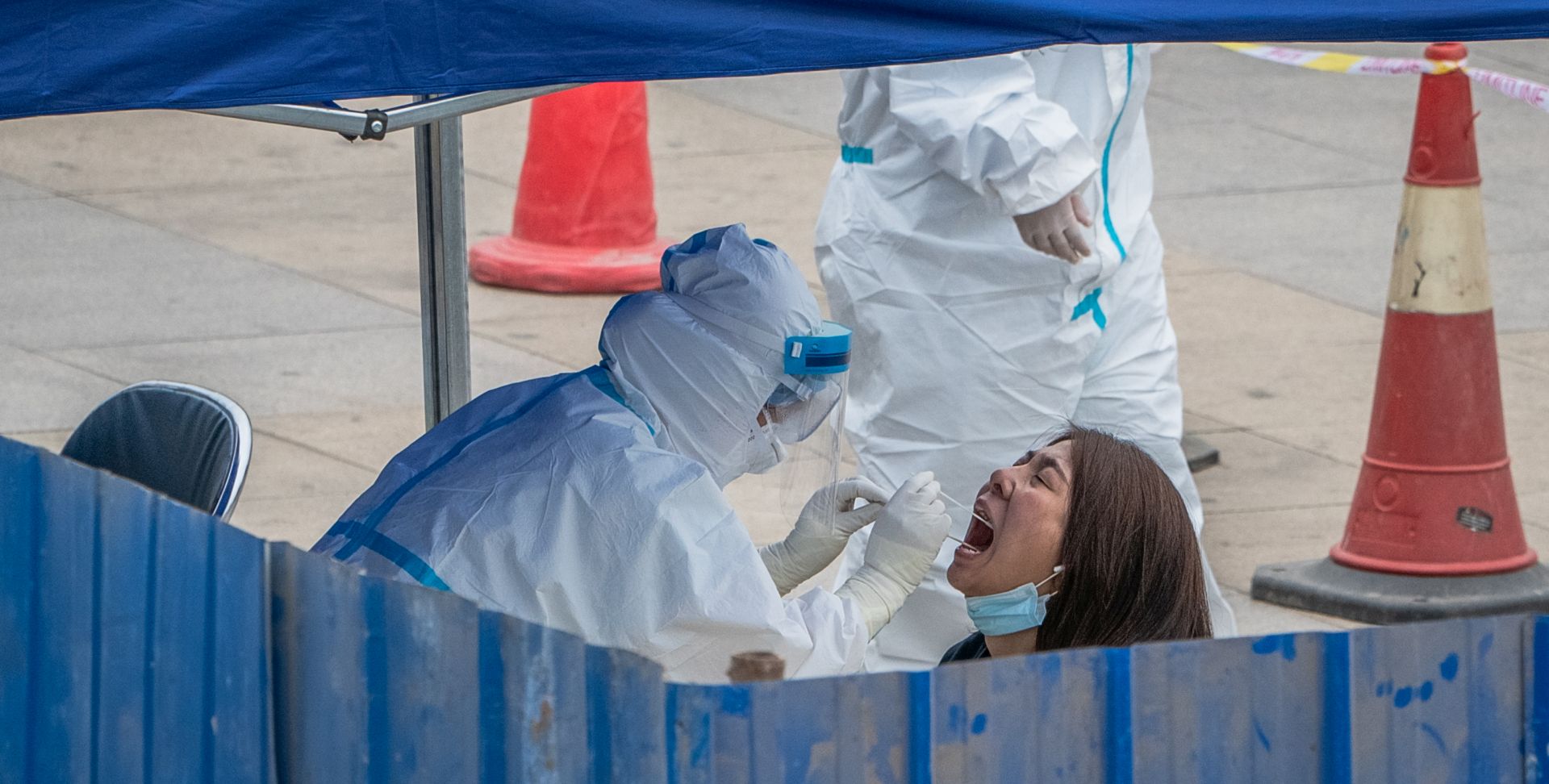 epa08490117 A woman is tested for COVID-19 at a makeshift coronavirus testing center, in Beijing, China, 17 June 2020. Beijing has given COVID-19 nucleic acid tests to 356,000 people since 13 June, according to the city's government officials, as the number of new coronavirus cases is continuing to increase in the city.  EPA/ROMAN PILIPEY