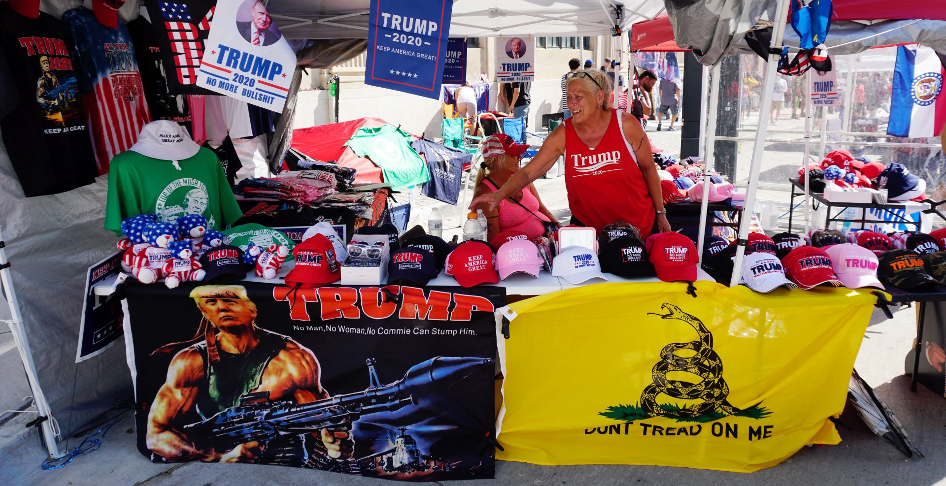 epaselect epa08499190 A vendor sells Trump campaingn items as crowds of protesters and supporters of US Presdient Donald J. Trump interact outside the fencing surrounding the Bank of Oklahoma Center hours before Trump holds a rally in Tulsa, Oklahoma, USA, 20 June 2020. The campaign rally is the first since the COVID-19 pandemic locked most of the country down in March 2020.  EPA/YOUNG G. KIM