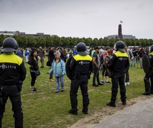 epa08500783 Police watch protesters in the center of The Hague, Netherlands, 21 June 2020. Demonstrators attended the protest on event venue Malieveld that focused on the coronavirus measures of the cabinet. The protest was initially banned due to an excessive number of interested people, but Mayor Remkes eventually allowed a short gathering.  EPA/ROBIN VAN LONKHUIJSEN