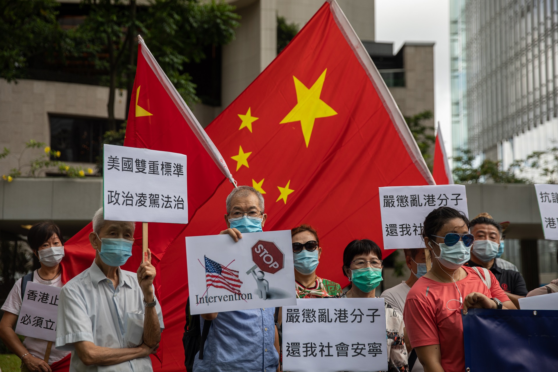 epa08509939 A group of pro-China activists hold banners and Chinese national flags during a march to the US Consulate General in Hong Kong, China, 26 June 2020. Demonstrators were protesting against the US Senate backed legislation that would impose mandatory sanctions on individuals or companies that back efforts by China to restrict Hong Kong's autonomy, as the government in Beijing moves to implement a new security law for the city and to denounce the US' 'intervention' in China's national affairs.  EPA/JEROME FAVRE