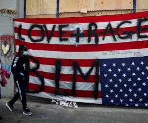 People protest at the CHAZ/CHOP zone around Seattle Police Department's East Precinct against racial inequality in the aftermath of the death in Minneapolis police custody of George Floyd, in Seattle People walk past an upside down American flag taped to the fence outside the Seattle Police Department's East Precinct at the self-proclaimed CHAZ/CHOP zone as people continue to protest against racial inequality in the aftermath of the death in Minneapolis police custody of George Floyd, in Seattle, Washington, U.S., June 14, 2020. REUTERS/Lindsey Wasson LINDSEY WASSON
