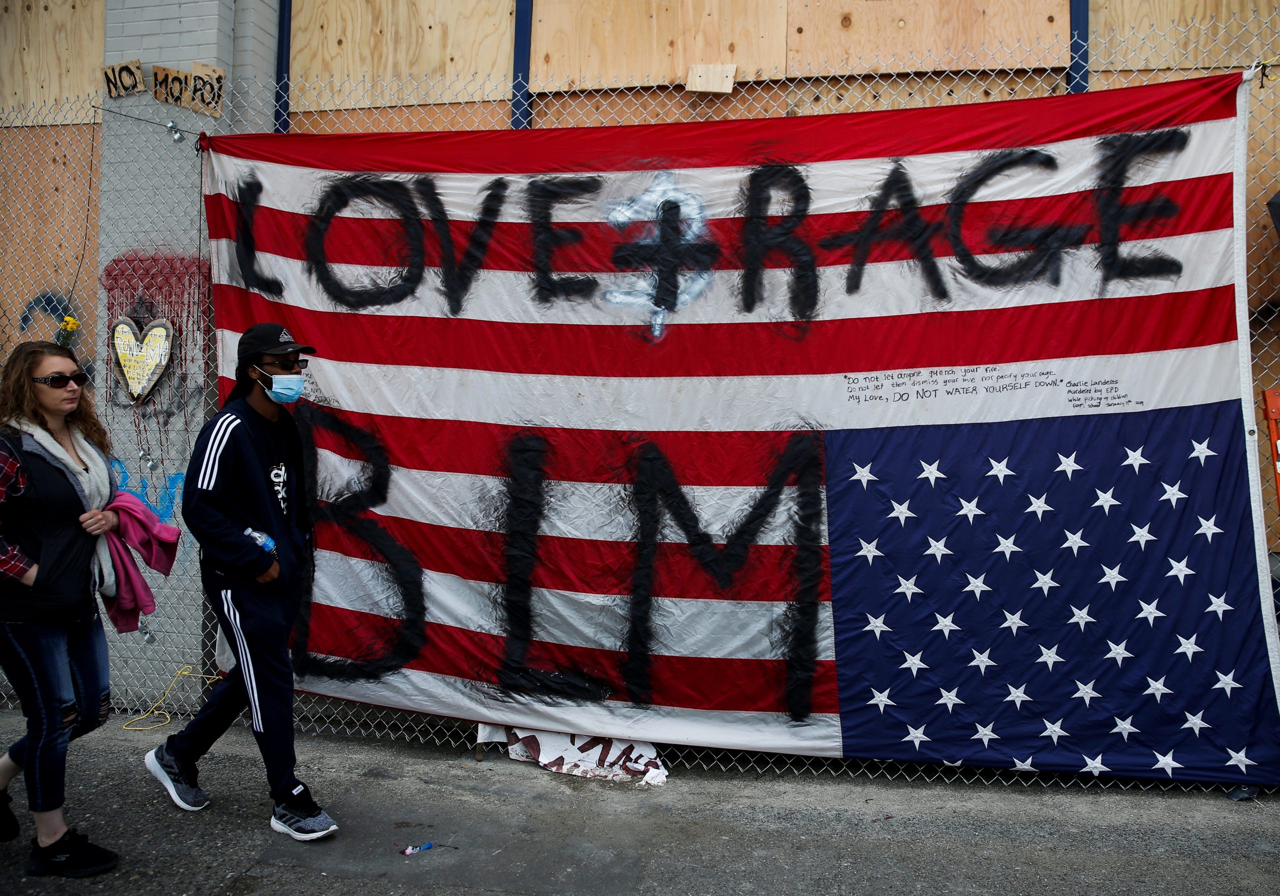People protest at the CHAZ/CHOP zone around Seattle Police Department's East Precinct against racial inequality in the aftermath of the death in Minneapolis police custody of George Floyd, in Seattle People walk past an upside down American flag taped to the fence outside the Seattle Police Department's East Precinct at the self-proclaimed CHAZ/CHOP zone as people continue to protest against racial inequality in the aftermath of the death in Minneapolis police custody of George Floyd, in Seattle, Washington, U.S., June 14, 2020. REUTERS/Lindsey Wasson LINDSEY WASSON