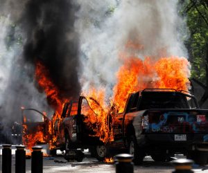 epa08466190 Two police cars burn after they were set on fire during a protest following the death of Giovanni Lopez, who died early May while in police custody in Ixtlahuacan de los Membrillos, in the city of Guadalajara, Mexico 04 June 2020. According to media reports, at least 20 people were arrested and two patrol cars were set on fire. Lopez was reportedly arrested on 04 May 2020 for not wearing a mask amid the coronavirus pandemic.  EPA/FRANCISCO GUASCO