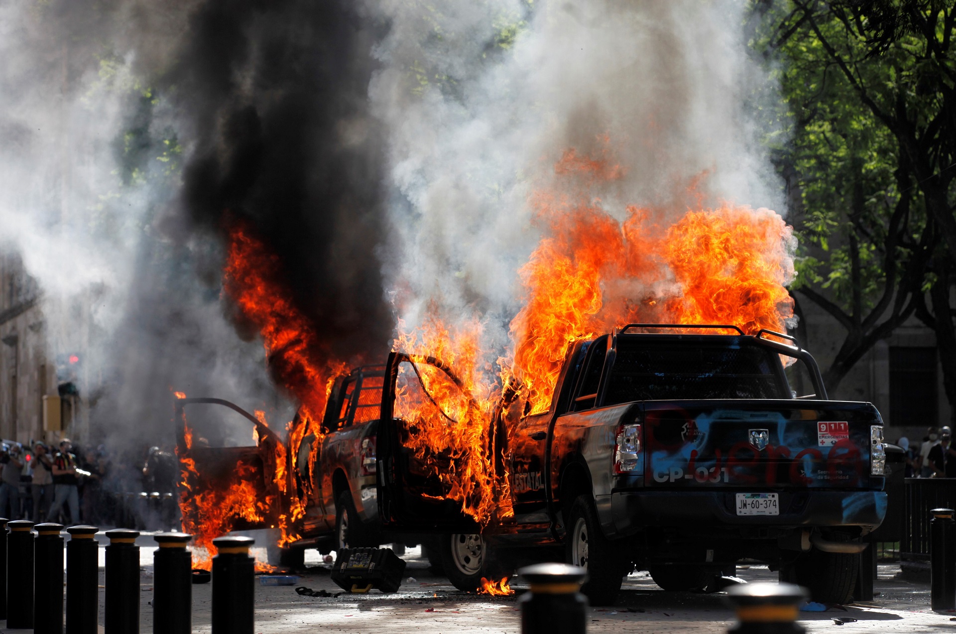 epa08466190 Two police cars burn after they were set on fire during a protest following the death of Giovanni Lopez, who died early May while in police custody in Ixtlahuacan de los Membrillos, in the city of Guadalajara, Mexico 04 June 2020. According to media reports, at least 20 people were arrested and two patrol cars were set on fire. Lopez was reportedly arrested on 04 May 2020 for not wearing a mask amid the coronavirus pandemic.  EPA/FRANCISCO GUASCO