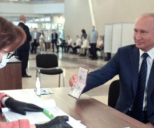 epa08519807 Russian President Vladimir Putin (R) shows his passport while taking part in a nationwide vote on amendments to the Russian Constitution during the main day of vote at a polling station in Moscow, Russia, 01 July 2020. The polling stations were opened for vote on 25 June to avoid crowding amid ongoing COVID-19 disease in Russia.  EPA/ALEXEI DRUZHININ / SPUTNIK / KREMLIN POOL MANDATORY CREDIT
