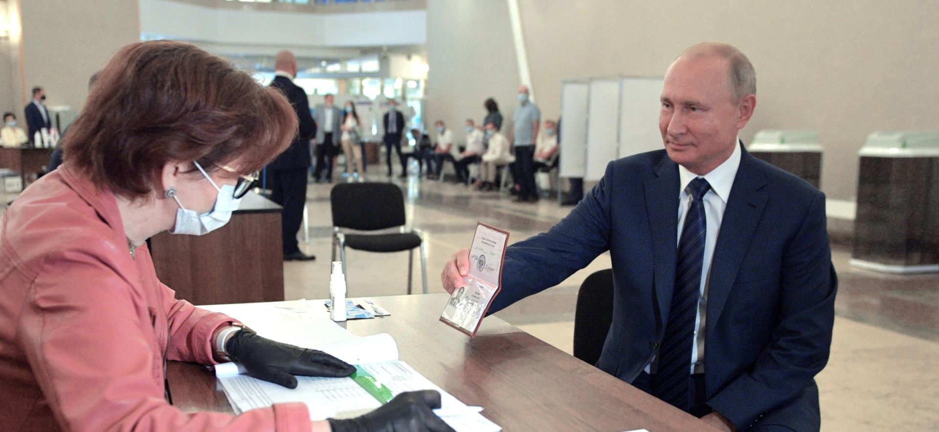 epa08519807 Russian President Vladimir Putin (R) shows his passport while taking part in a nationwide vote on amendments to the Russian Constitution during the main day of vote at a polling station in Moscow, Russia, 01 July 2020. The polling stations were opened for vote on 25 June to avoid crowding amid ongoing COVID-19 disease in Russia.  EPA/ALEXEI DRUZHININ / SPUTNIK / KREMLIN POOL MANDATORY CREDIT