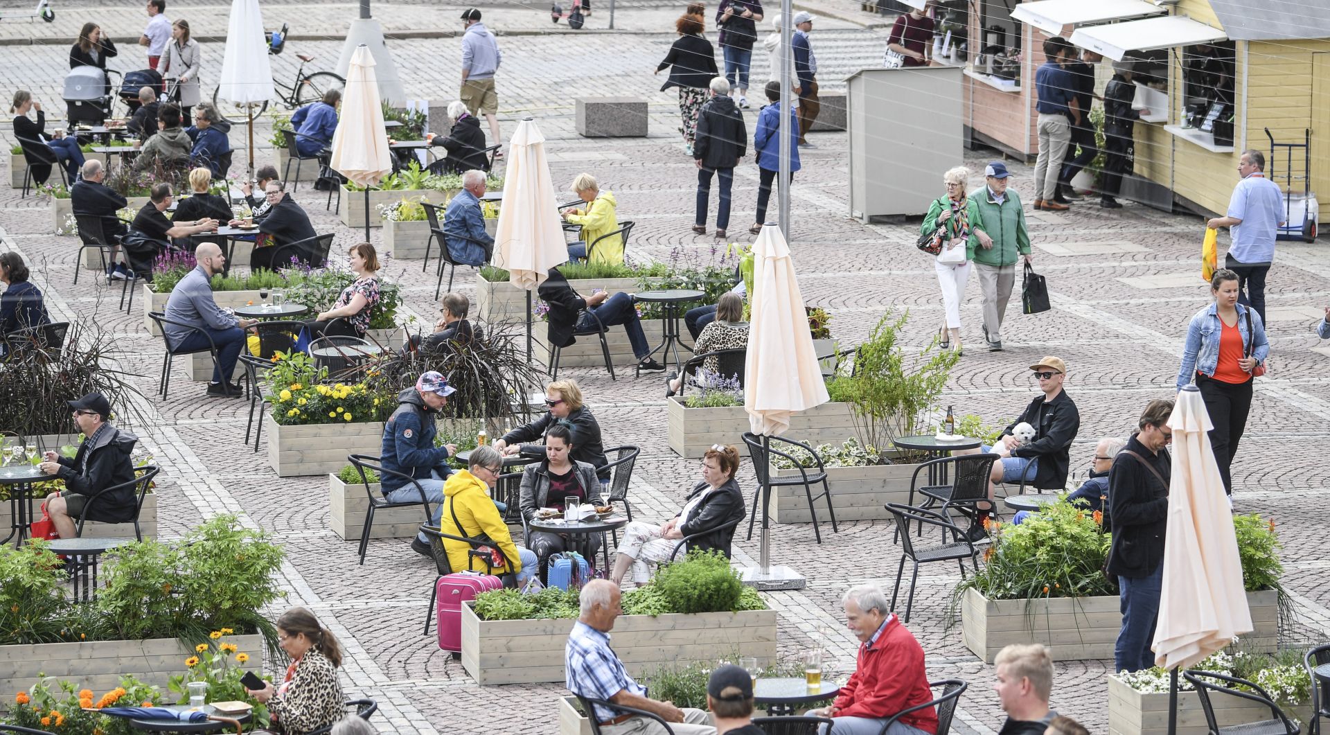 epa08520262 People sit on the Super Terrace that has been opened at Senate Square in Helsinki, Finland, 01 July 2020. It provides seating for 480 people and a number of pop-up restaurants to be introduced to the square as a means of allowing safer dining in the age of COVID-19. The terrace is open until the end of August 2020.  EPA/KIMMO BRANDT