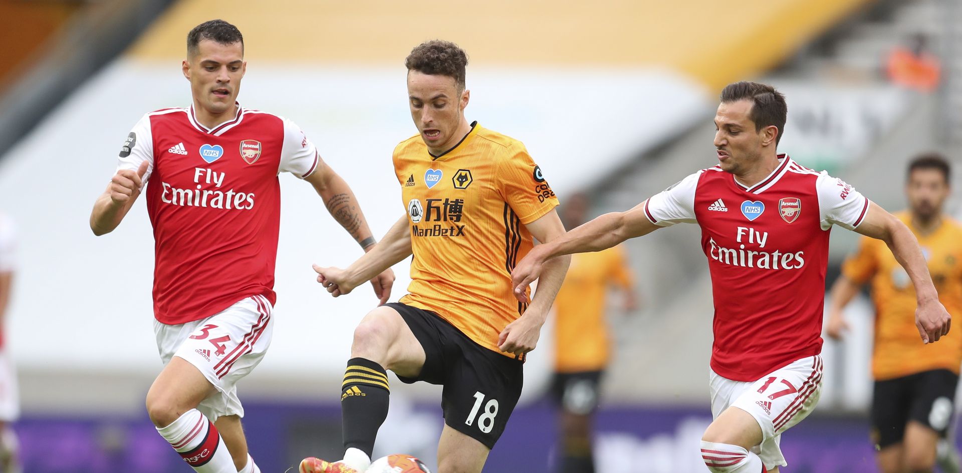 epa08527278 Diogo Jota (C) of Wolverhampton in action against Granit Xhaka (L) and Cedric Soares (R) of Arsenal during the English Premier League match between Wolverhampton Wanderers and Arsenal London in Wolverhampton, Britain, 04 July 2020.  EPA/Cath Ivill/NMC/Pool EDITORIAL USE ONLY. No use with unauthorized audio, video, data, fixture lists, club/league logos or 'live' services. Online in-match use limited to 120 images, no video emulation. No use in betting, games or single club/league/player publications.