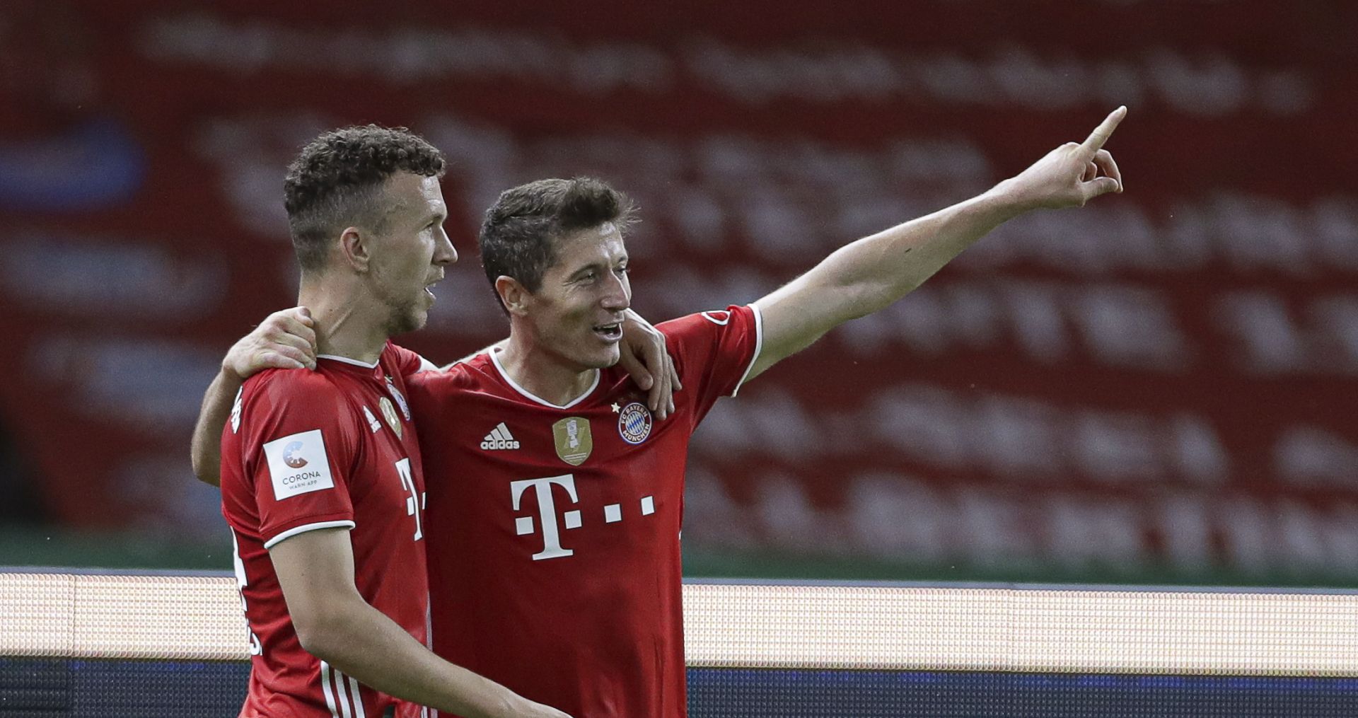 epa08527929 Robert Lewandowski (R) of Bayern Munich celebrates with teammate Ivan Perisic (L) after scoring the 4-1 lead during the German DFB Cup final between Bayer 04 Leverkusen and FC Bayern Munich at Olympic Stadium in Berlin, Germany, 04 July 2020.  EPA/MICHAEL SOHN / POOL CONDITIONS - ATTENTION: The DFB regulations prohibit any use of photographs as image sequences and/or quasi-video.