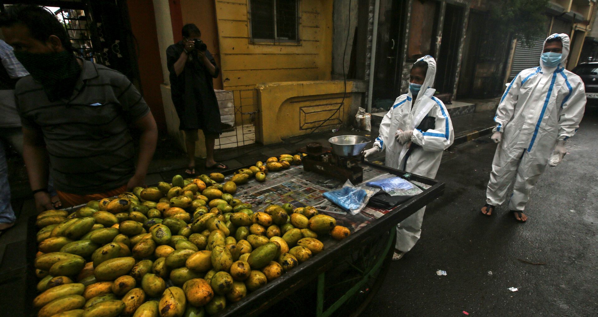 epa08529065 Indian health workers wearing personal protective equipment (PPE) arrive to carry medical checkup of the residents of a 'containment zones' during heavy rains in Mumbai, India, 05 July 2020. According to media reports, the state government of Maharashtra extended the lockdown till 31 July, with some relaxation in the ongoing lockdown.  EPA/DIVYAKANT SOLANKI