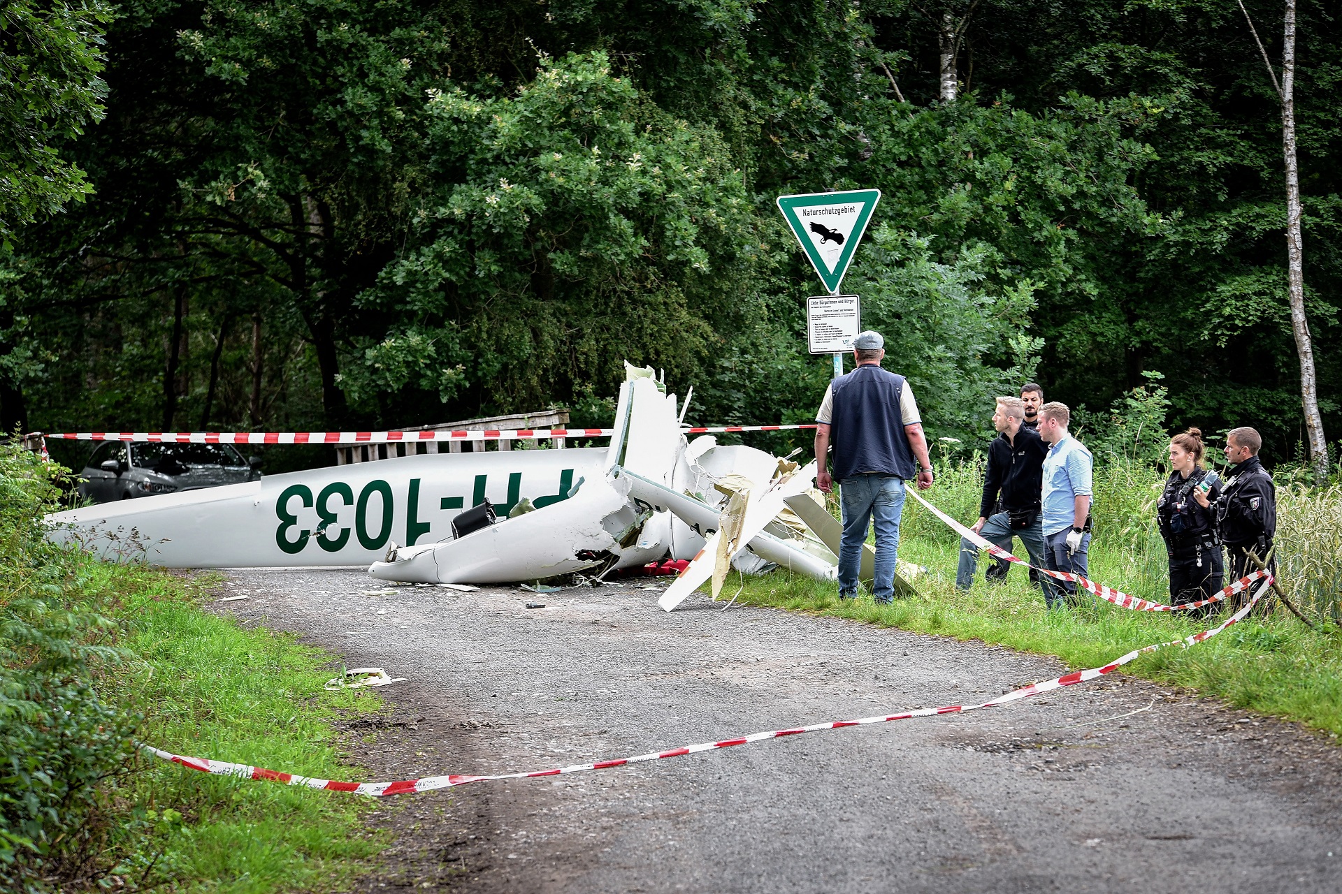 epa08541010 Police officers inspect the wreckage of a plane that crashed in Duelmen, Germany, 11 July 2020. For reasons still unknown, two gliders collided and crashed in mid-air over a wooded area at Silbersee between Duelmen and Haltern am See. Both gliders were completely destroyed. According to initial information, the two pilots of the planes died in the crash.  EPA/VINCENT KEMPF