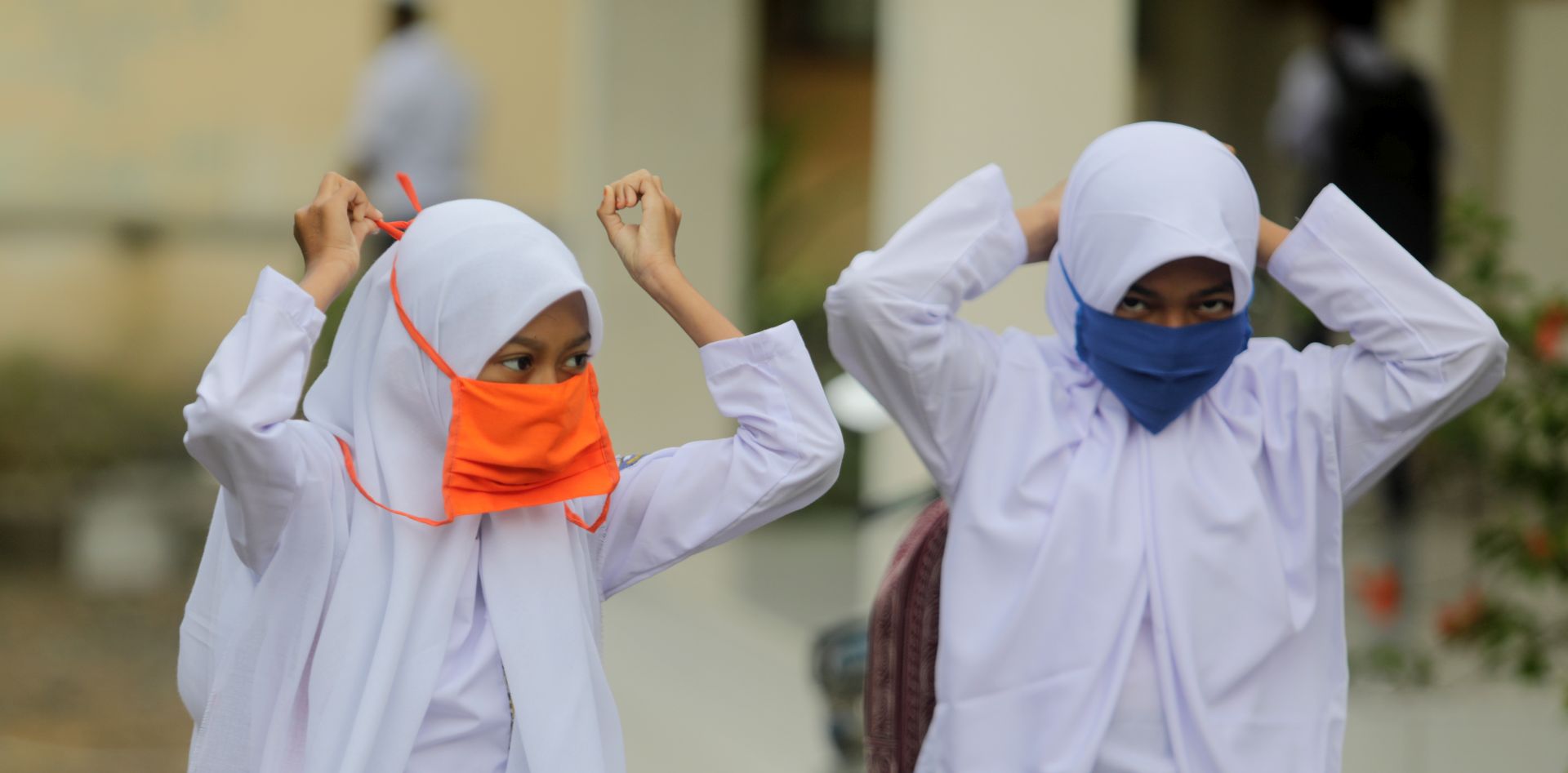 epa08542840 Students put on masks during the first day of school in Sibreh, Aceh, Indonesia, 13 July 2020. The Indonesian government began to reopen some schools in low-risk areas. The online learning method is still enforced in several other areas. The government has started to ease COVID-19 lockdown restrictions in an effort to restart the economy after more than three months of disruption caused by the ongoing pandemic.  EPA/HOTLI SIMANJUNTAK