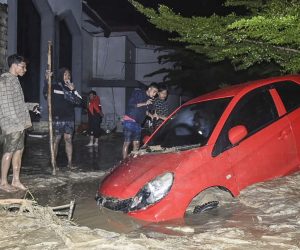 epa08545089 People inspect a damage car after it was hit by flash floods in Mssamba, Luwu Utara, South Sulawesi, Indonesia, 14 July 2020. According to Indonesian National Board for Disaster Management (BNPB), at least 10 people are dead and dozens of others missing.  EPA/STR