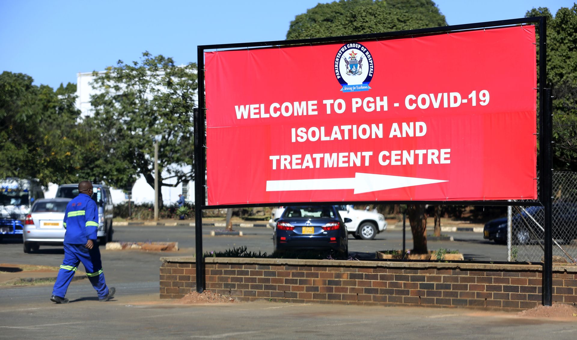 epa08547495 A man walks past a billboard pointing to a COVID-19 treatment centre at Parirenyatwa Hospital in Harare, Zimbabwe, 15 July 2020. President Emmerson Mnangagwa has said he will soon announce new lockdown measures to further curb the spread of the disease.  EPA/AARON UFUMELI