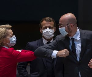 epa08553177 European Commission President Ursula von der Leyen (L) and European Council President Charles Michel (R) greet each other with an elbow bump as French President Emmanuel Macron (C) looks on at the start of the second day of an EU summit in Brussels, Belgium, 18 July 2020. European Union nations leaders meet face-to-face for the first time since February to discuss plans responding to coronavirus crisis and new long-term EU budget at the special European Council on 17 and 18 July.