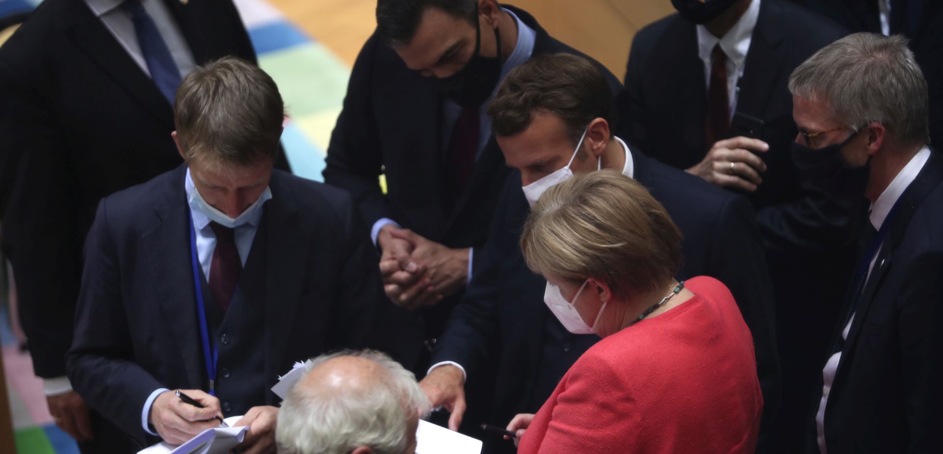 epa08557210 German Chancellor Angela Merkel (C-R) chats with French President Emmanuel Macron (C), Spanish Prime Minister Pedro Sanchez (C-L) and other dignitaries while they all wear face masks during a roundtable discussion on the fourth day of the ongoing Special European Council leaders' summit, the first face-to-face meeting between EU statespeople held since the eruption of the ongoing pandemic of the COVID-19 disease caused by the SARS-CoV-2 coronavirus, in Brussels, Belgium, 20 July 2020. The heads of state and government discussed the bloc's response to the pandemic and the new long-term budget.  EPA/FRANCISCO SECO / POOL
