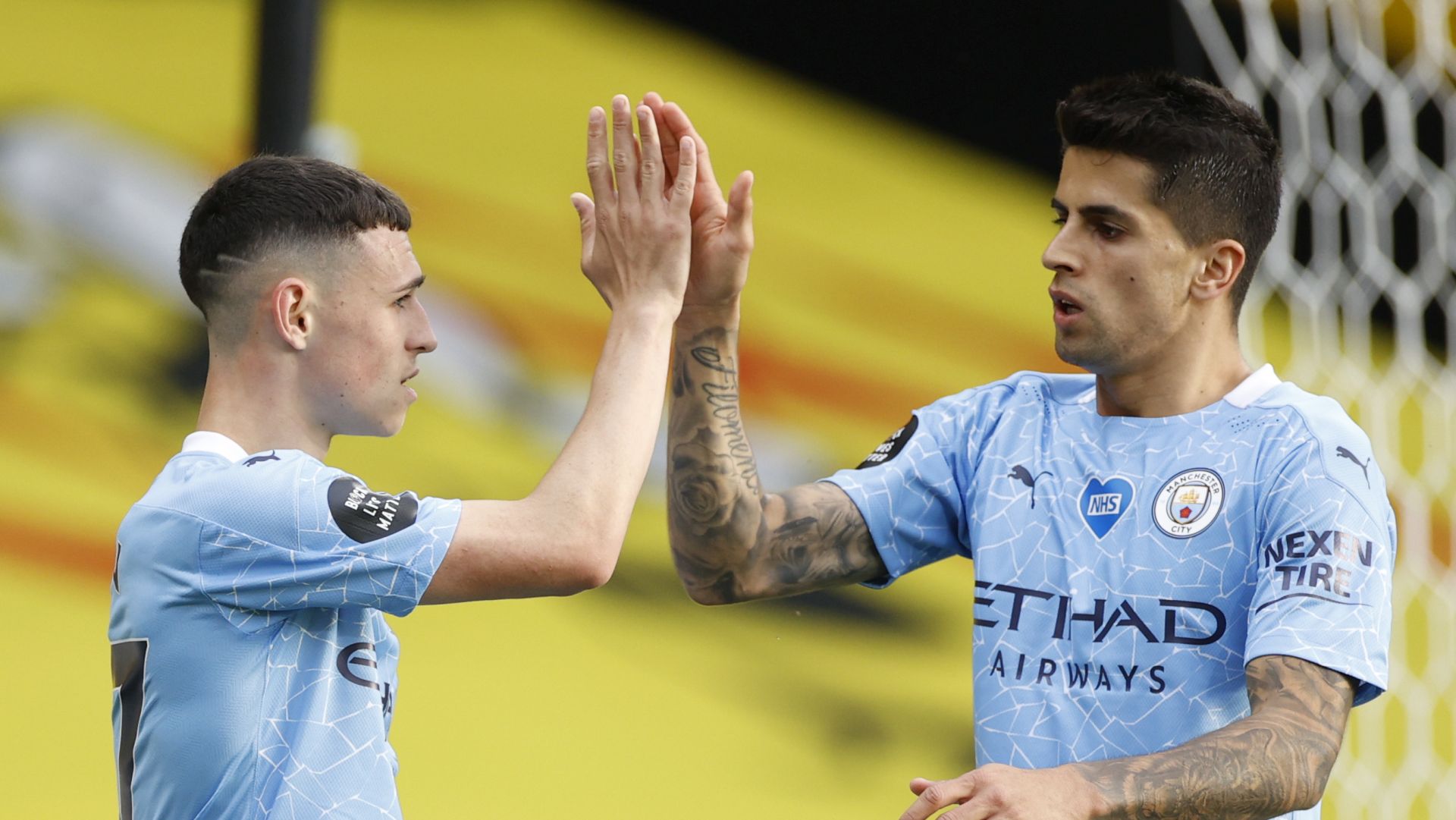 epa08559101 Phil Foden (L) of Manchester City celebrates with Joao Cancelo (R) of Manchester City  after scoring a goal during the English Premier League match between Watford and Manchester City in Watford, Britain, 21 July 2020.  EPA/John Sibley/NMC/Pool EDITORIAL USE ONLY. No use with unauthorized audio, video, data, fixture lists, club/league logos or 'live' services. Online in-match use limited to 120 images, no video emulation. No use in betting, games or single club/league/player publications.