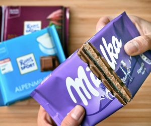 epa08559694 ILLUSTRATION - A woman dividing a bar of Milka chocolate in half, in Duesseldorf, Germany, 17 July 2020 (issued 22 July 2020). Three years ago, the German Federal Court (BGH) already dealt with the Milka manufacturer's attempt to take away the monopoly on the square shape of its cocoa products from its competitor Ritter Sport. With varying degrees of success: the German Patent and Trademark Office had resisted the request because the packaging design had established itself on the market as a distinctive mark and was not technically necessary. However, the Federal Patent Court then deleted the three-dimensional shape mark at the request of Milka, which sells its products in purple packaging - a square is also just a special shape of a rectangle. After further legal arguments, the BGH intends to announce the significance of the aesthetic and functional aspects of sweets and the slogan ‘Square. Practical. Good’ from its point of view for the nibbling public, on 23 July 2020.  EPA/SASCHA STEINBACH