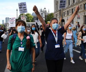 epa08572841 NHS workers wearing protective face masks stage a protest march to Downing Street in London, Britain, 29 July 2020. NHS nurses who have been on the frontline for some five months fighting Coronavirus marched to Downing Street calling for a pay rise.  EPA/ANDY RAIN