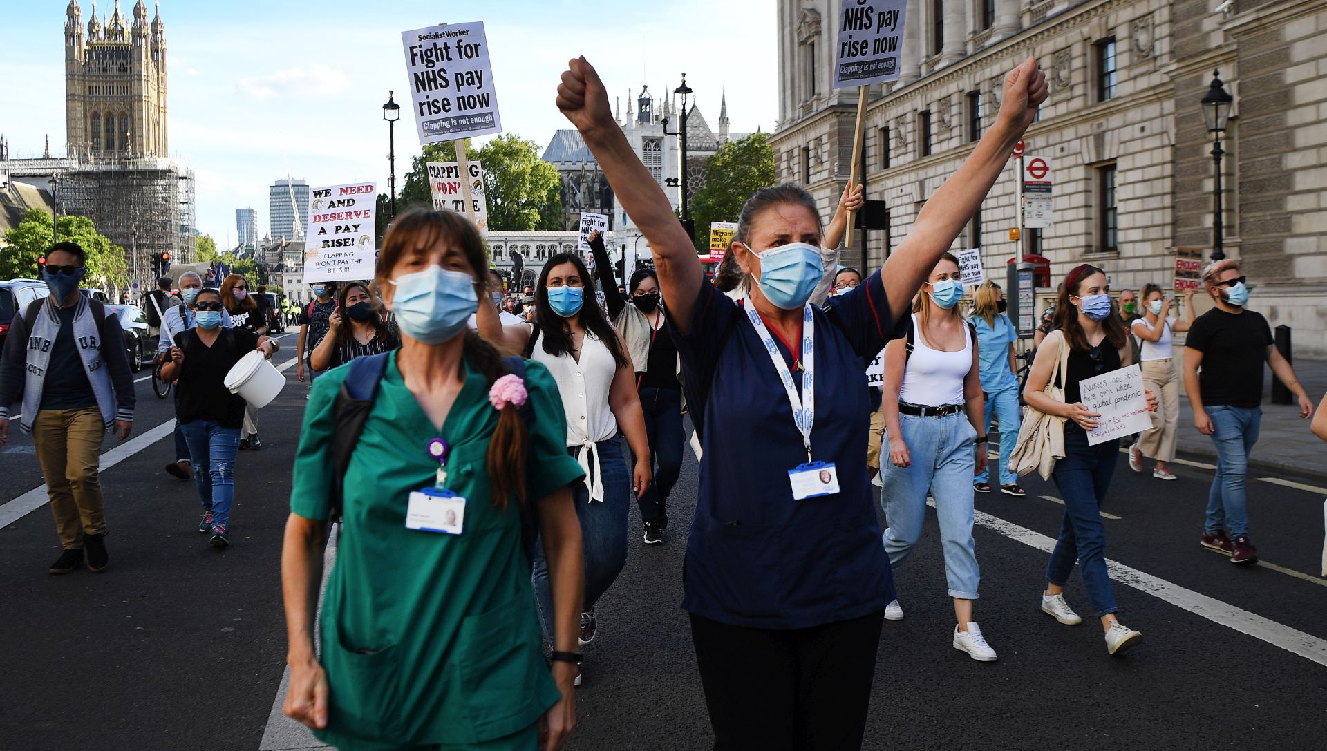 epa08572841 NHS workers wearing protective face masks stage a protest march to Downing Street in London, Britain, 29 July 2020. NHS nurses who have been on the frontline for some five months fighting Coronavirus marched to Downing Street calling for a pay rise.  EPA/ANDY RAIN