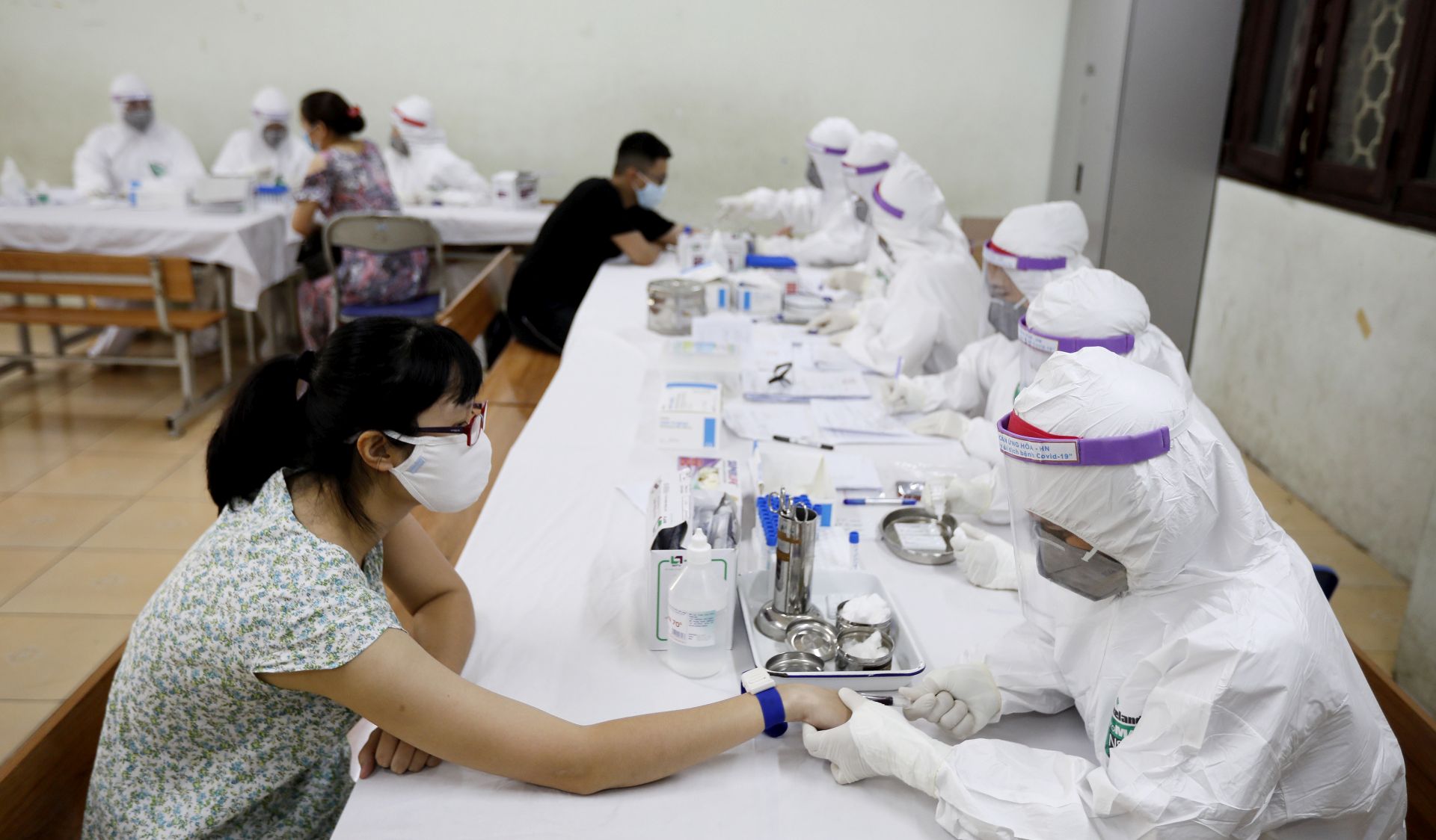 epa08575765 A woman who returned from Da Nang city has her blood tested at a makeshift rapid testing centre for coronavirus disease (COVID-19) in Hanoi, Vietnam 31 July 2020. The country reported on 31 July 45 new cases of infection, its biggest single-day jump since the beginning of the pandemic.  EPA/LUONG THAI LINH