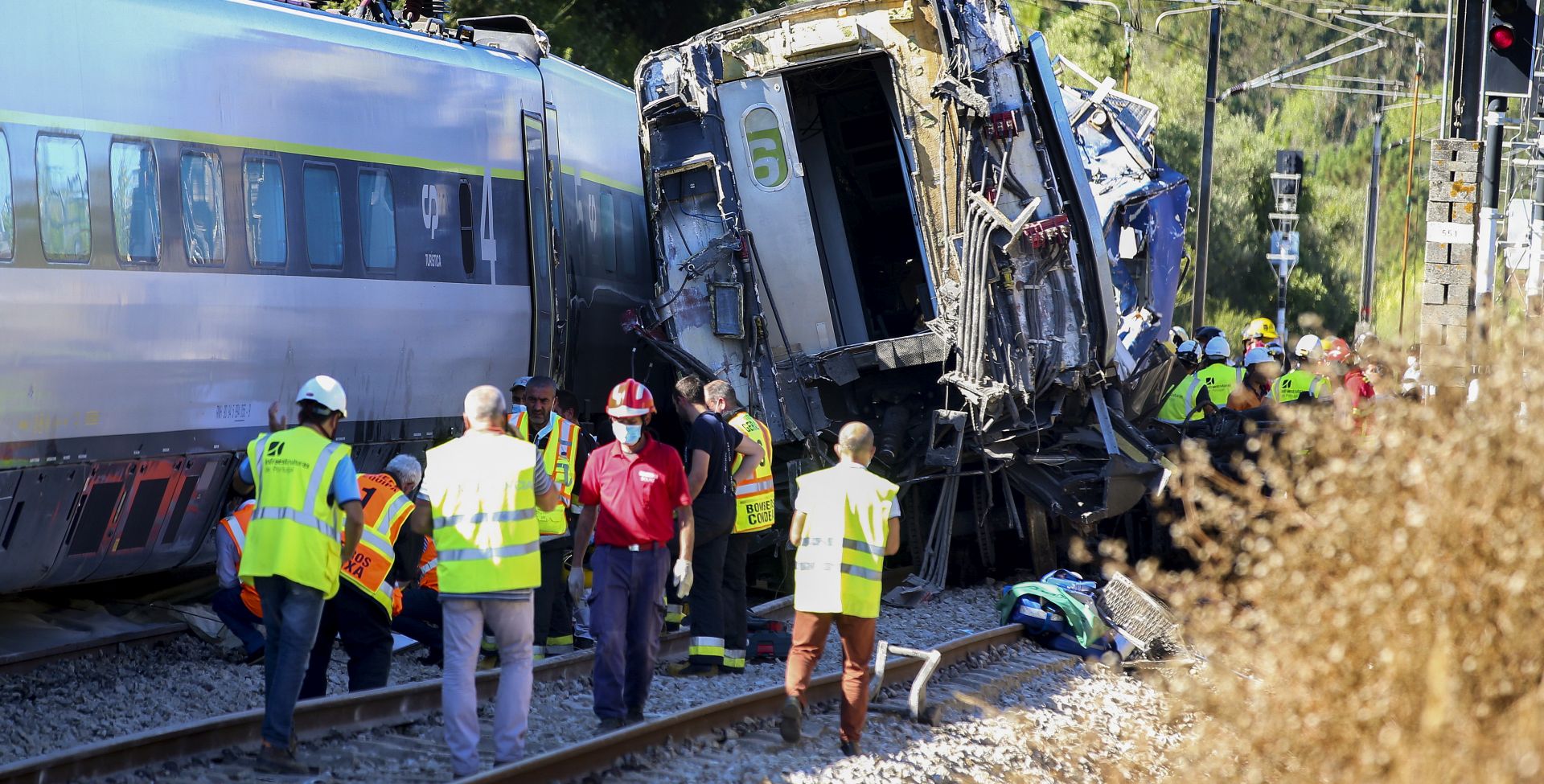 epa08577597 Rescue services at a site of a train crash in Soure, Coimbra, center of Portugal, 31 July 2020. According to reports 72 vehicles with 181 operational and and two planes are being mobilized for the crash site after a train derailed after a collision with maintenance machine leaving at least one person dead and about 50 other passengers injured.  EPA/PAULO CUNHA