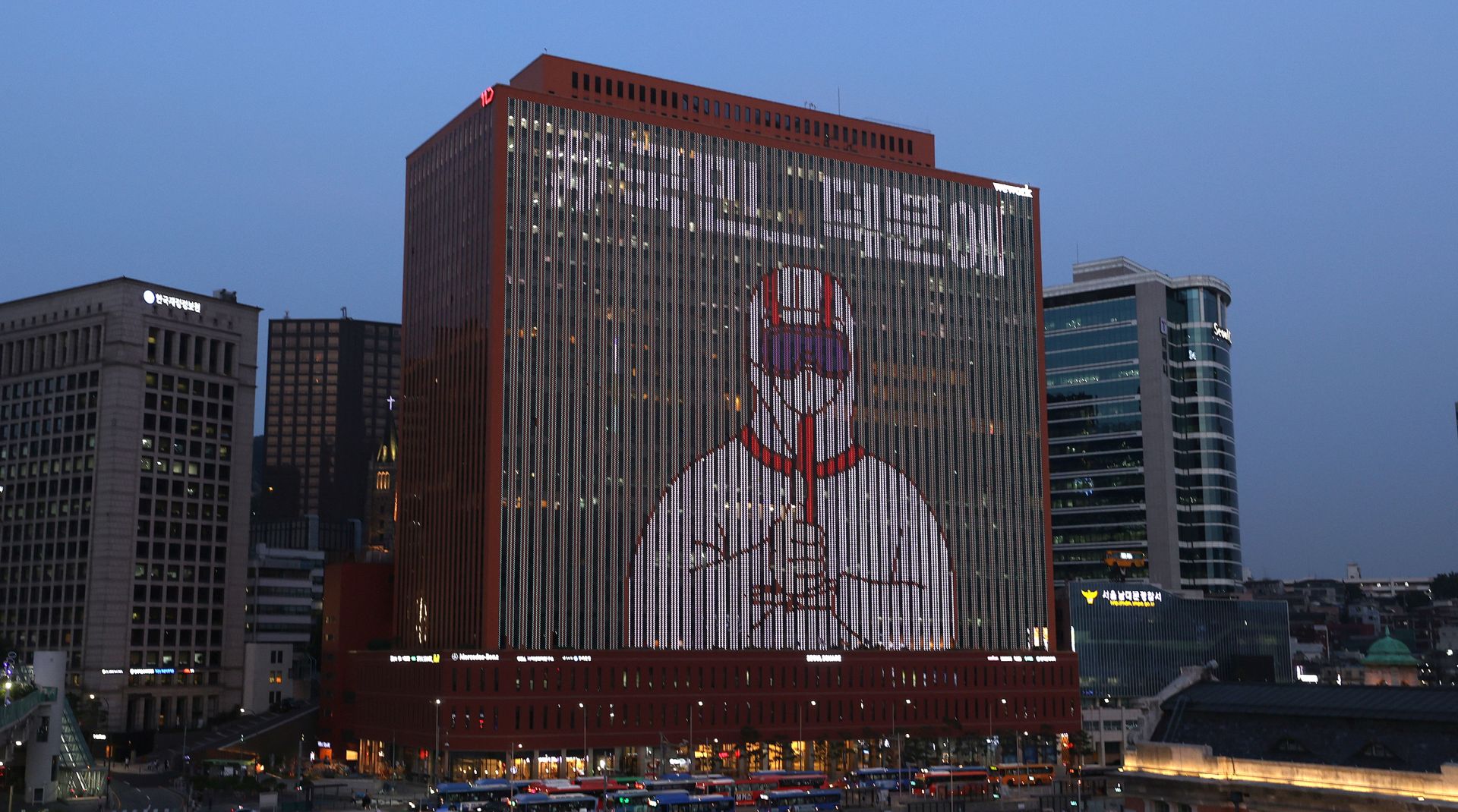 epa08534358 A video featuring an image of a person in protective clothing giving a thumbs-up is displayed on the wall of a building in central Seoul, south Korea, 08 July 2020, as part of a campaign to show appreciation to medical workers and health officials for their efforts in fighting the coronavirus pandemic.  EPA/YONHAP SOUTH KOREA OUT