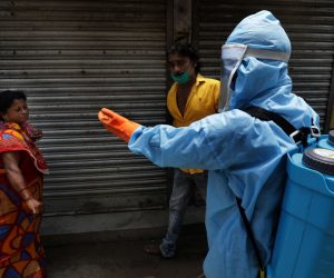 epa08571961 A municipal worker requests a meber of the public wear a mask as he sanitizes a containment zone near Kolkata, India, 29 July 2020. According to media reports, India has confirmed nearly 1 million cases of coronavirus.  EPA/PIYAL ADHIKARY