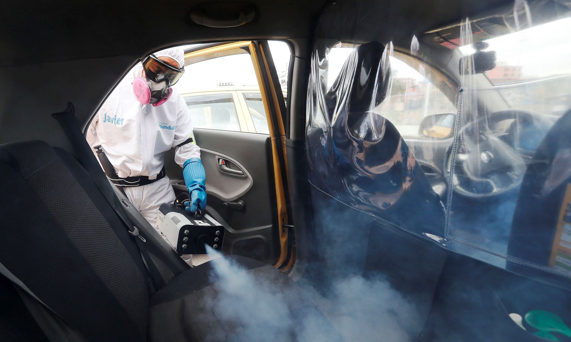 epaselect epa08573514 A worker disinfects the interior of a taxi in Bogota, Colombia, 29 July 2020. Colombia is the new focus of the pandemic in Latin America, with a high rate of infections that has already reached 10,000 daily, a situation that led the Government to extend the quarantine for another month, a measure received with skepticism by experts given the numerous exceptions in force. The country, which accumulates more than 267,000 infections, completes a month with daily figures of more than 7,000 cases, statistics focused mainly on Bogotá and Medellin.  EPA/Carlos Ortega