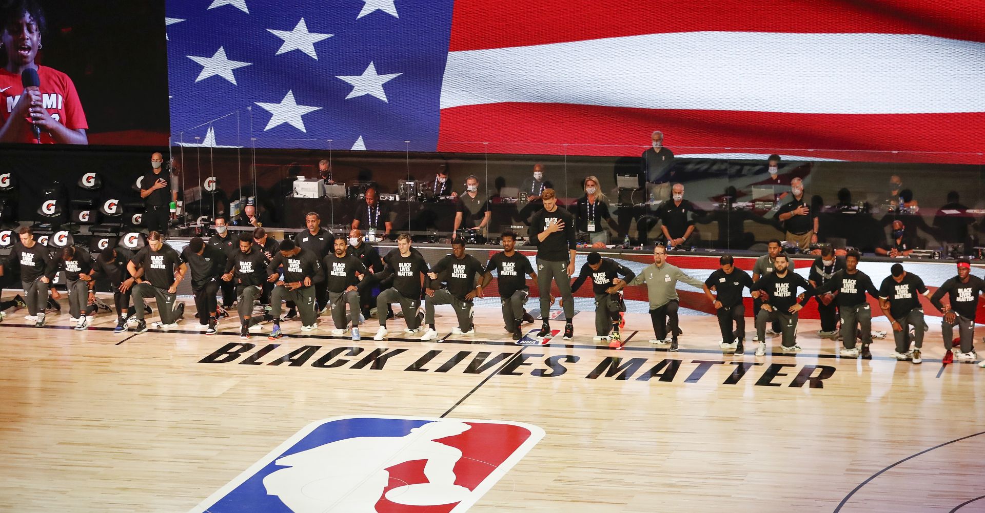epa08582308 Members of the Toronto Raptors and the Miami Heat kneel during the National Anthem before the start of the NBA basketball game between the Toronto Raptors and the Miami Heat at the ESPN Wide World of Sports Complex in Kissimmee, Florida, USA, 03 August 2020. The NBA season has restarted at the Walt Disney World sports complex outside Orlando, Florida.  EPA/ERIK S. LESSER SHUTTERSTOCK OUT