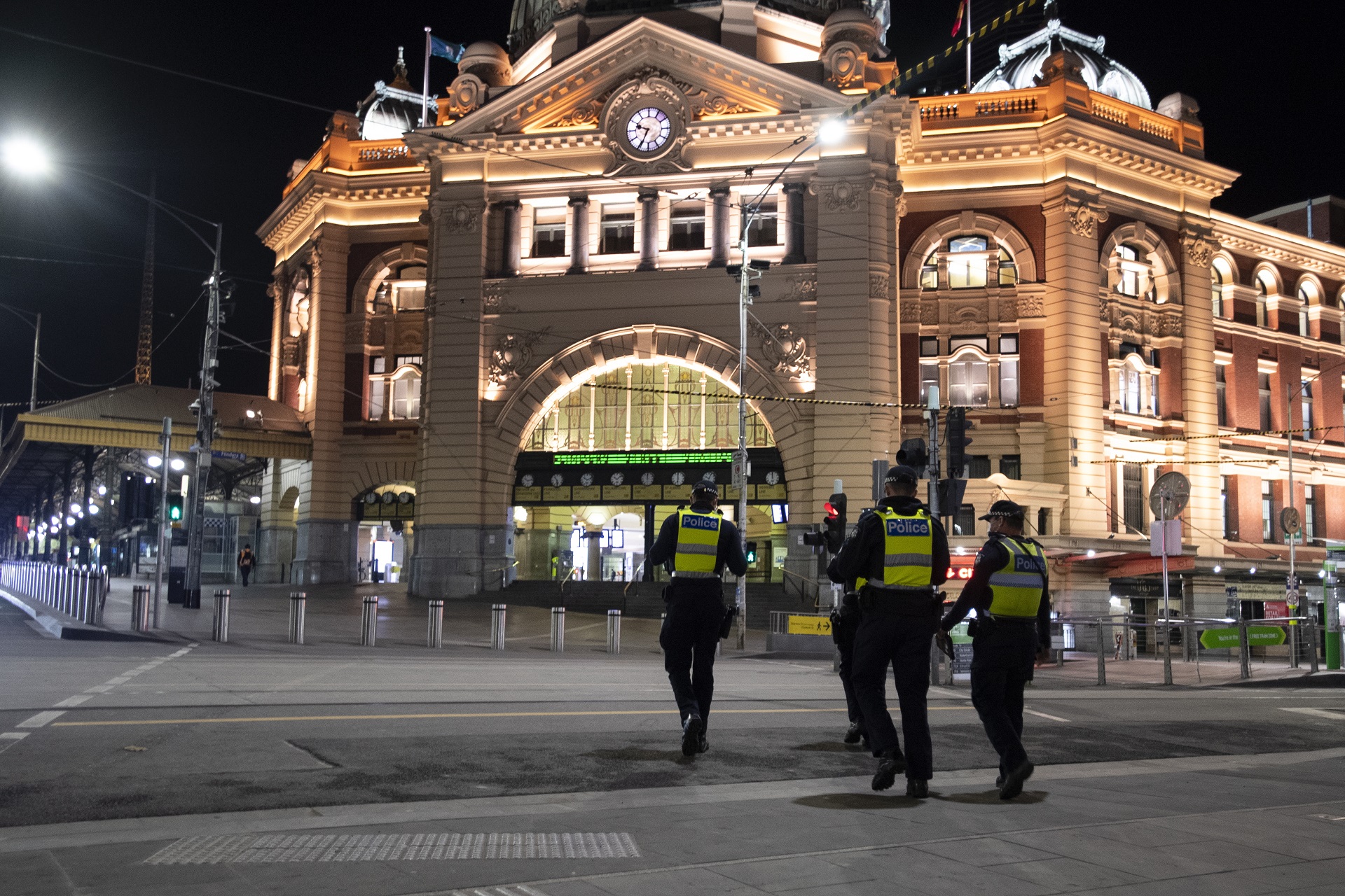 epa08591736 Police in front of Flinders Street Station during a 8PM-5AM curfew in Melbourne, Victoria, Australia, 08 August 2020. Victoria's second coronavirus disease (COVID-19) wave is stabilizing, according to authorities who expect case numbers to drop within the next two weeks.  EPA/ERIK ANDERSON  AUSTRALIA AND NEW ZEALAND OUT