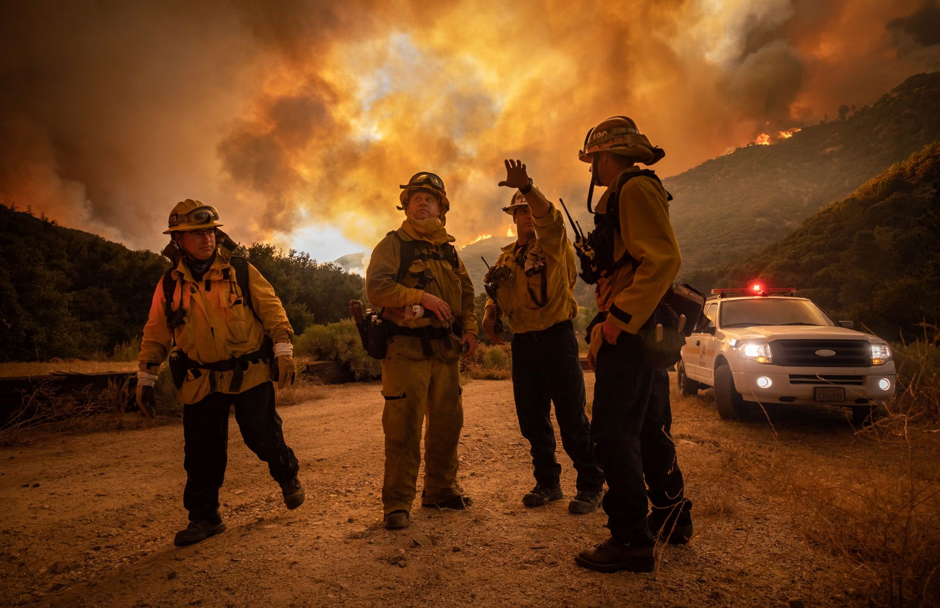 epaselect epa08600280 Firefighters make an escape plan as the Lake Fire burns a hillside in Lake Hughes, California, USA, 12 August 2020.  EPA/CHRISTIAN MONTERROSA