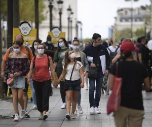 epa08605148 Pedestrians wear protective face masks as they walk through the Champs Elysee district, in Paris, France, 15 August 2020. Face masks became mandatory in some districts of Paris starting 10 August amid rising concerns over a second wave of coronavirus infections.  EPA/JULIEN DE ROSA