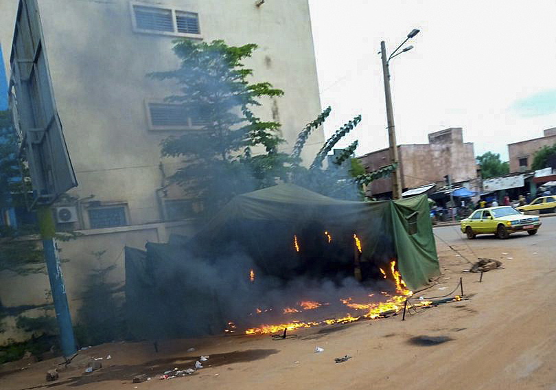 epa08611404 A roadside stall burns following looting after Mali military entered the streets of Bamako, Mali 18 August 2020. Local reports indicate Mali military have seized Mali President Ibrahim Boubakar Keïta in what appears to be a coup attempt.  EPA/STR
