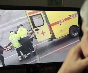 epa08613985 A person (R) in Moscow watches a video on social media showing Russian opposition activist and anti-corruption fund head Alexei Navalny being carried on a stretcher by an ambulance team, in Omsk, Russia, 20 August 2020. Navalny's spokeswoman Kira Yarmysh said on social media on 20 August that the opposition leader and critic of President Vladimir Putin was taken to hospital for alleged poisoning after he started feeling unwell during a flight from Siberia to Moscow. The plane made an emergency landing in the city of Omsk.  EPA/SERGEI CHIRIKOV
