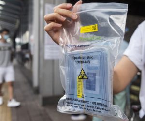 epa08613956 A resident shows a free COVID-19 test kit distributed by the government at the Cheung Sha Wan Government Offices building in Sham Shui Po, Hong Kong, China, 20 August 2020. Hong Kong is expected to launch a citywide voluntary COVID-19 testing program on 01 September 2020 to combat a new wave of coronavirus infection.  EPA/MIGUEL CANDELA