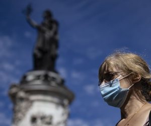 epa08616218 A woman wearing protective face masks walks across Place de la Republique in Paris, France, 21 August 2020. Paris has been declared a zone of 'active circulation' for the coronavirus SARS-CoV-2 which causes the Covid-19 disease. Cases in France have surged in recent weeks, with 4770 new cases recorded in a 24 hour period.  EPA/IAN LANGSDON