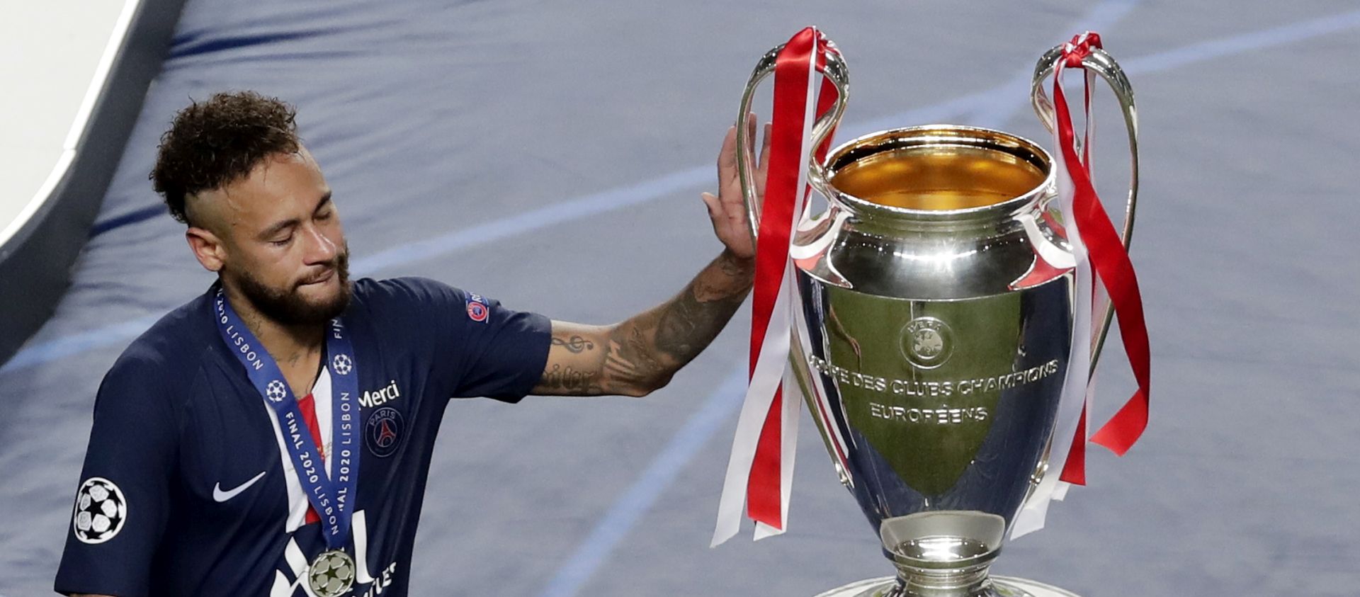 epa08620908 Neymar of PSG touches the trophy after receiving his runner-up medal after the UEFA Champions League final between Paris Saint-Germain and Bayern Munich in Lisbon, Portugal, 23 August 2020. PSG lost 0-1.  EPA/Manu Fernandez / POOL