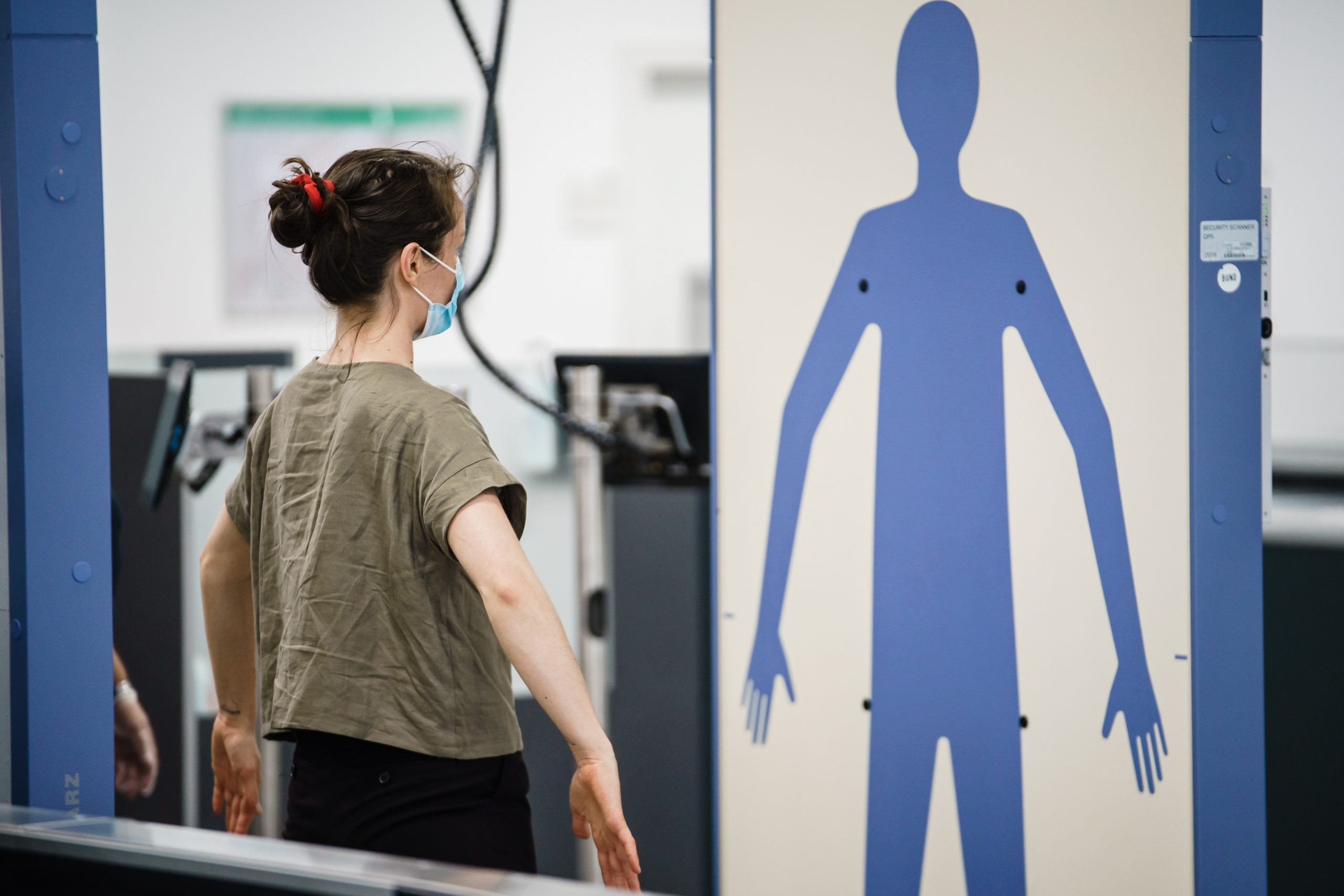 epa08622928 A passenger stands in a body scanner at the security check zone at Berlin-Schoenefeld airport during a press tour in Schoenefeld, Germany, 24 August 2020. The company Airport Berlin Brandenburg invited the press for a tour of Schoenefeld airport. The terminal T5 becomes part of the soon to be opened BER airport. The opening of BER airport is scheduled for 31 October 2020.  EPA/CLEMENS BILAN