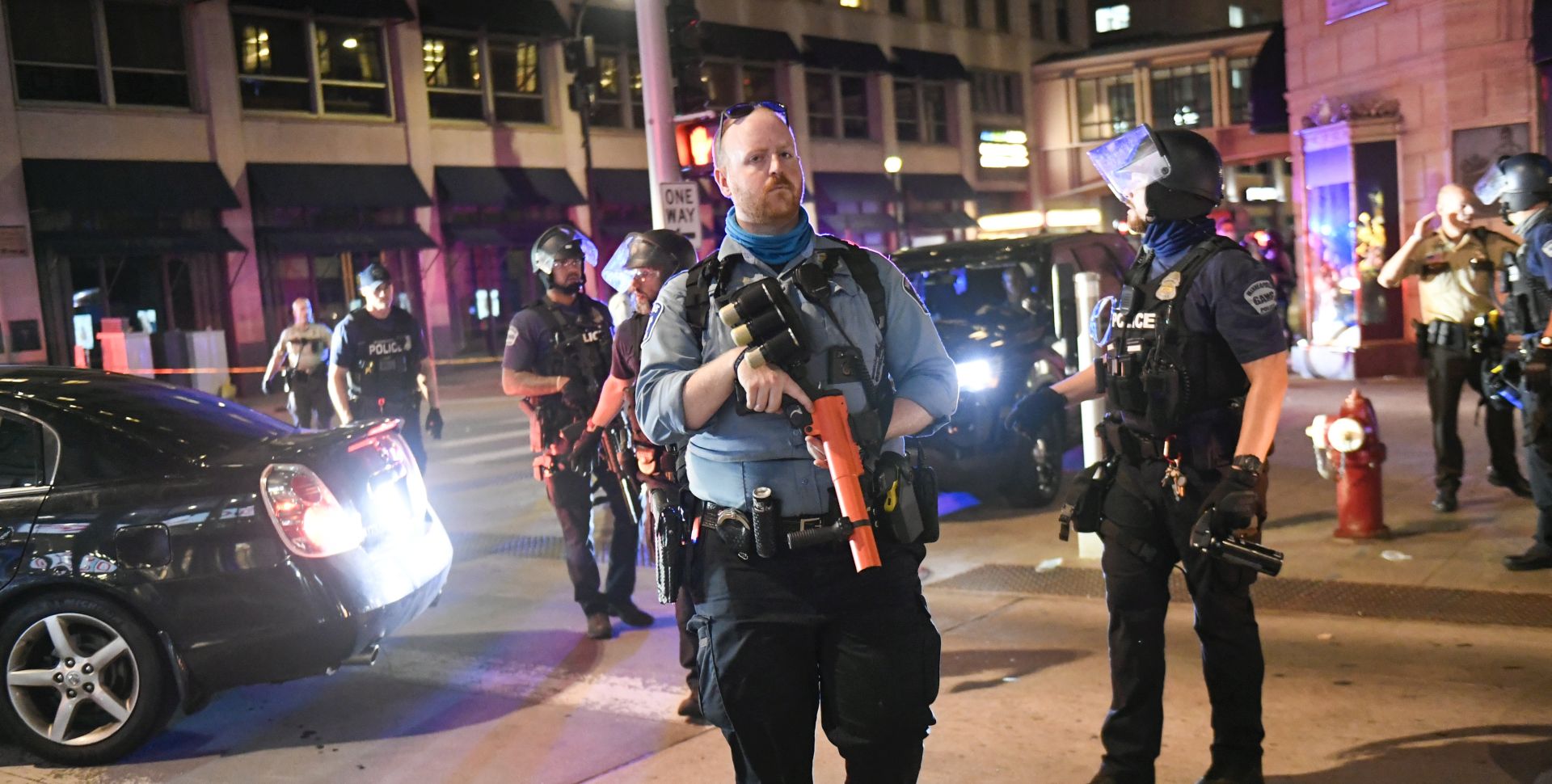 epa08628102 Police officers stand guard as protesters and rioters clash with police after a homicide suspect killed himself as police closed in on him in downtown Minneapolis, Minnesota, USA, 26 August 2020. Rumors swirled that police shot and killed the Black man but nearby security video confirmed the suicide.  EPA/CRAIG LASSIG