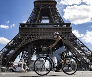 epa08629169 A woman wearing a protective face mask rides her bicycle near the Eiffel Tower, in Paris, France, 27 August 2020. French Prime Minister Jean Castex has announced that measures are being taken to enforce mask-wearing across the entire city of Paris, which has been declared a zone of 'active circulation' for the coronavirus SARS-CoV-2 which causes the Covid-19 disease. Cases in France have surged in recent weeks, with over 5000 new cases recorded in a 24 hour period.  EPA/IAN LANGSDON