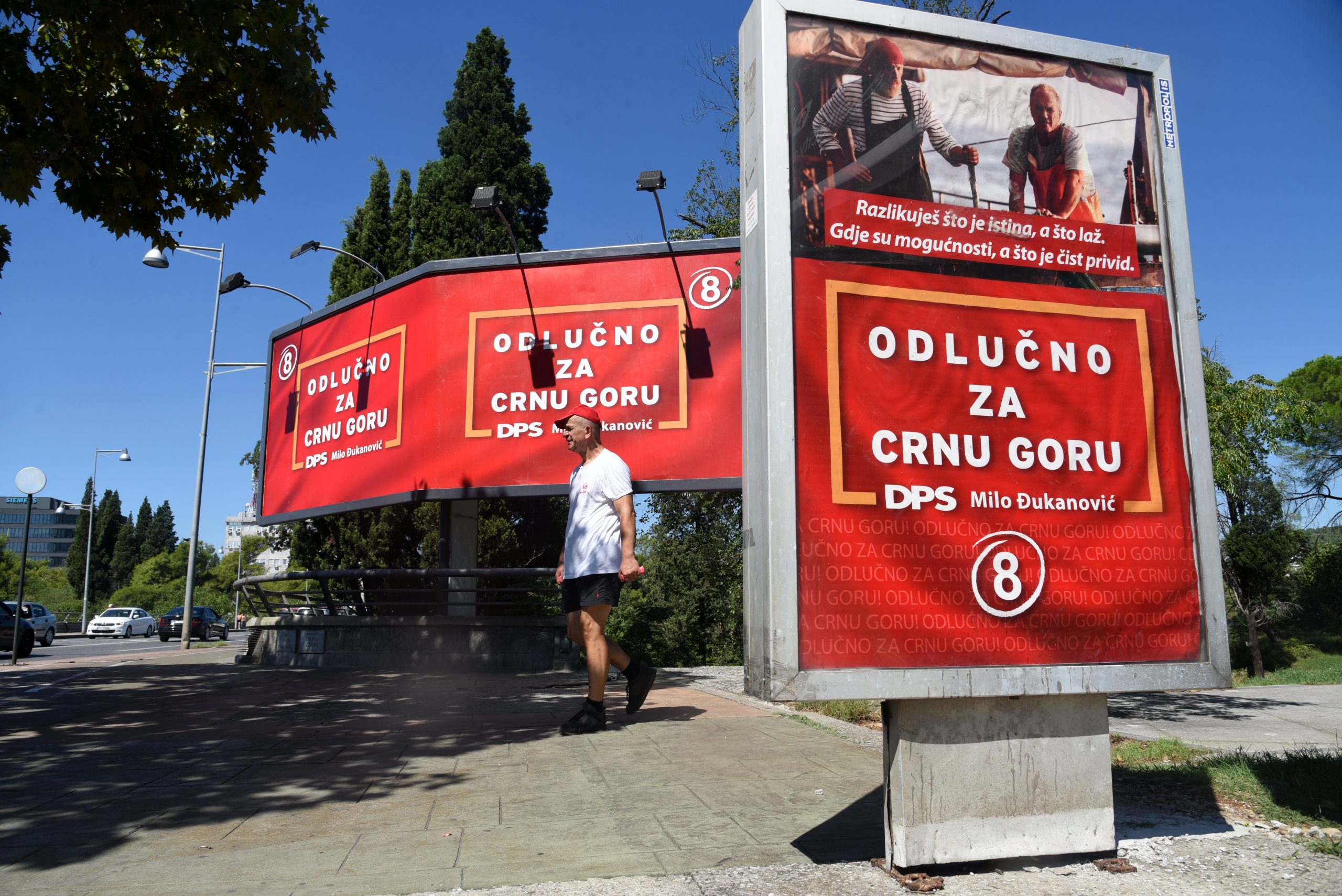 epa08629361 A man walks past a row of campaign billboards of the ruling Democratic Party of Socialists (DPS) of incumbent President Milo Djukanovic ahead of the upcoming parliamentary elections, in Podgorica, Montenegro, 27 August 2020. Parliamentary elections are due to be held in Montenegro on 30 August 2020.  EPA/BORIS PEJOVIC