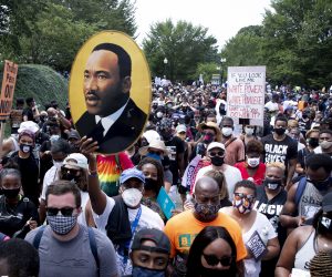 epa08632791 The image of Martin Luther King Jr. is seen among the crowd marching from the Lincoln Memorial to the Martin Luther King Jr. Memorial during the 'Commitment March: Get Your Knee Off Our Necks', in Washington, DC, USA, 28 August 2020. The March on Washington comes on the 57th anniversary of Dr. Martin Luther King's historic march, when he delivered his 'I Have a Dream' speech.  EPA/MICHAEL REYNOLDS