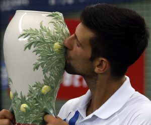 epa08634598 Novak Djokovic of Serbia kisses the Rookwood Cup trophy after defeating Milos Raonic of Canada during their Men's finals match at the Western and Southern Open at the USTA National Tennis Center in Flushing Meadows, New York, USA, 29 August 2020.  EPA/JASON SZENES
