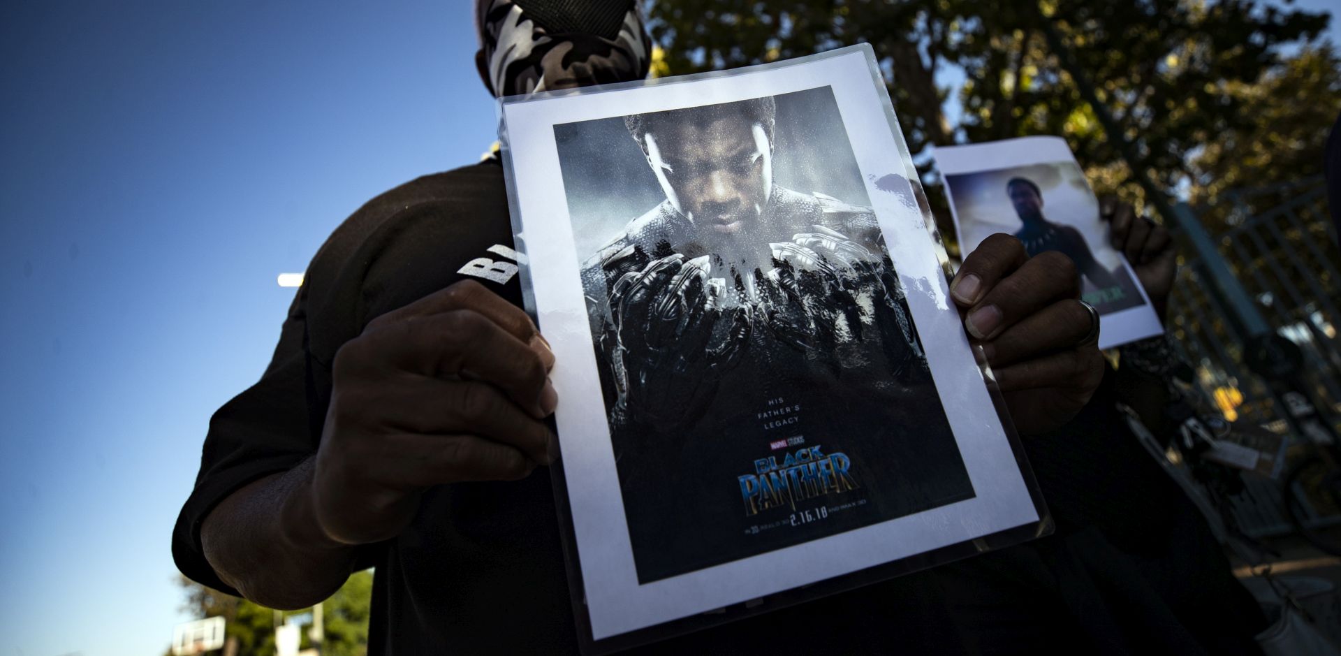 epaselect epa08634840 A man holds a picture of late US actor Chadwick Boseman during a vigil to honor his memory in Leimert Park, Los Angeles, California, USA, 29 August 2020. Chadwick Boseman passed away, age 43, after a four year battle with colon cancer.  EPA/ETIENNE LAURENT