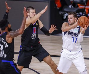 epa08636352 Dallas Mavericks guard Luka Doncic of Slovenia (R) in action against Los Angeles Clippers center Ivica Zubac of Croatia (C) and Los Angeles Clippers forward Marcus Morris Sr. (L) during the first half of the NBA basketball first-round Western Conference playoff game six between the Los Angeles Clippers and the Dallas Mavericks at the ESPN Wide World of Sports Complex in Kissimmee, Florida, USA, 30 August 2020.  EPA/JOHN G. MABANGLO SHUTTERSTOCK OUT